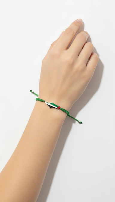 Hand wearing a green bracelet on a white background